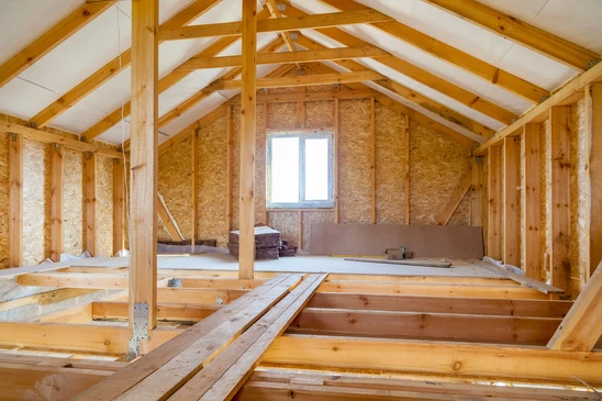 Chantier de construction résidentielle en cours, combles aménageables avec charpente bois apparente