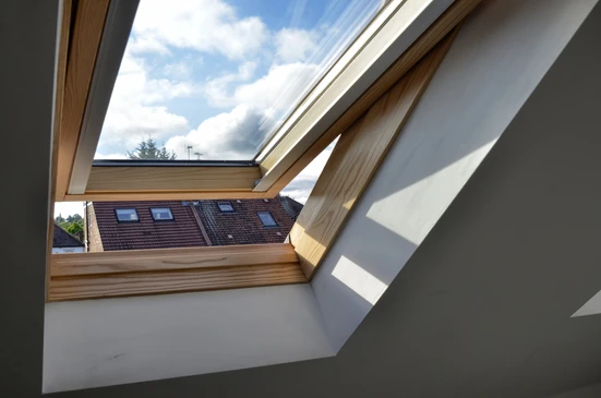 Intérieur d'une chambre sous combles avec fenêtre de toit ouverte en position ventilation